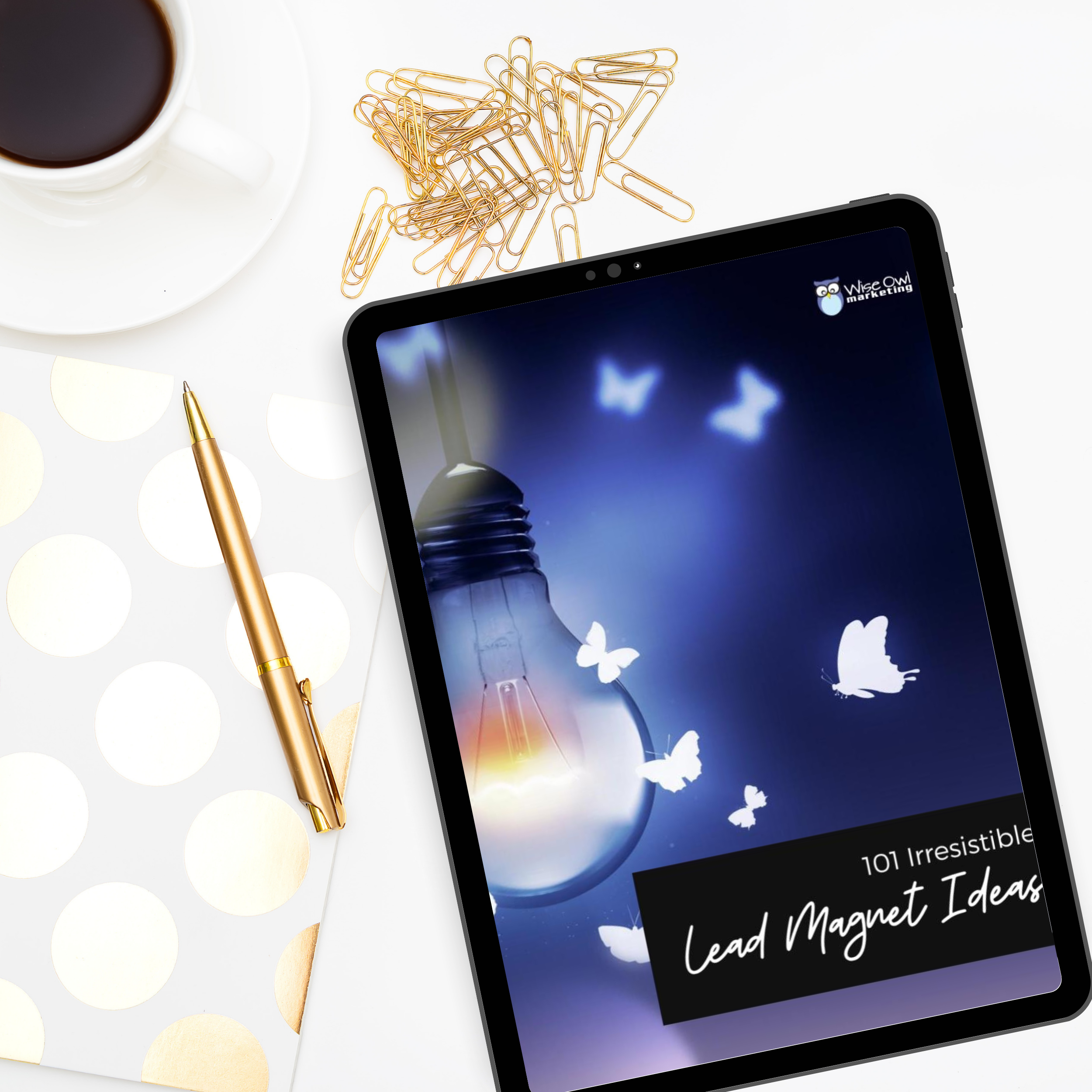 desk with gold accessories and an ipad mockup showing the cover of 101 lead magnet ideas with a light bulb attracting butterflies