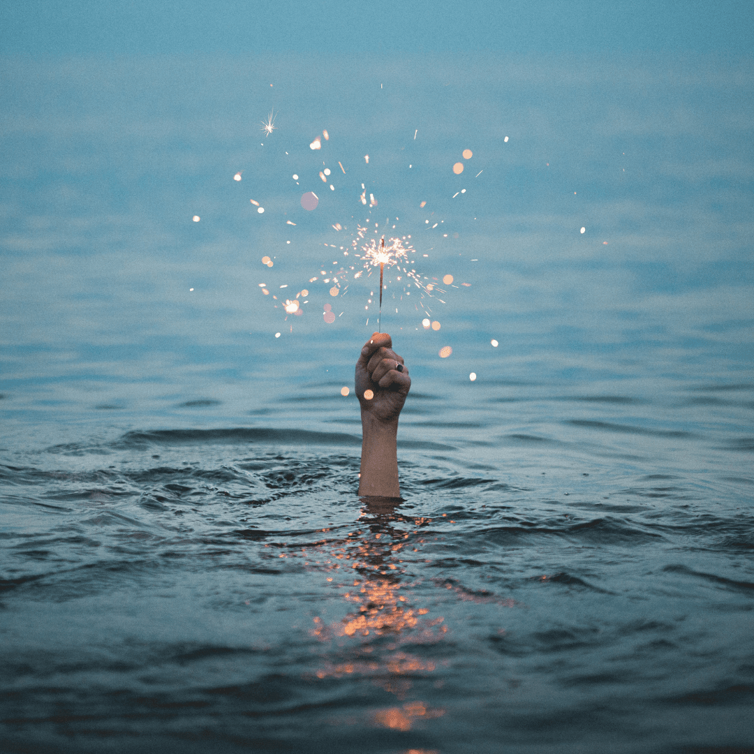 woman holding sparkler above water - she's drowning